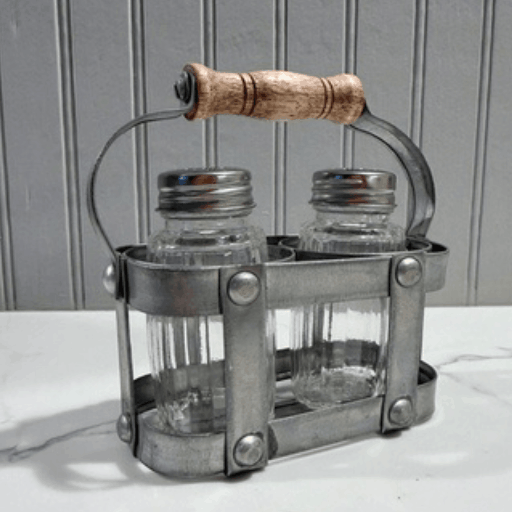 Metal salt and pepper shaker set with wooden handle on a neutral background